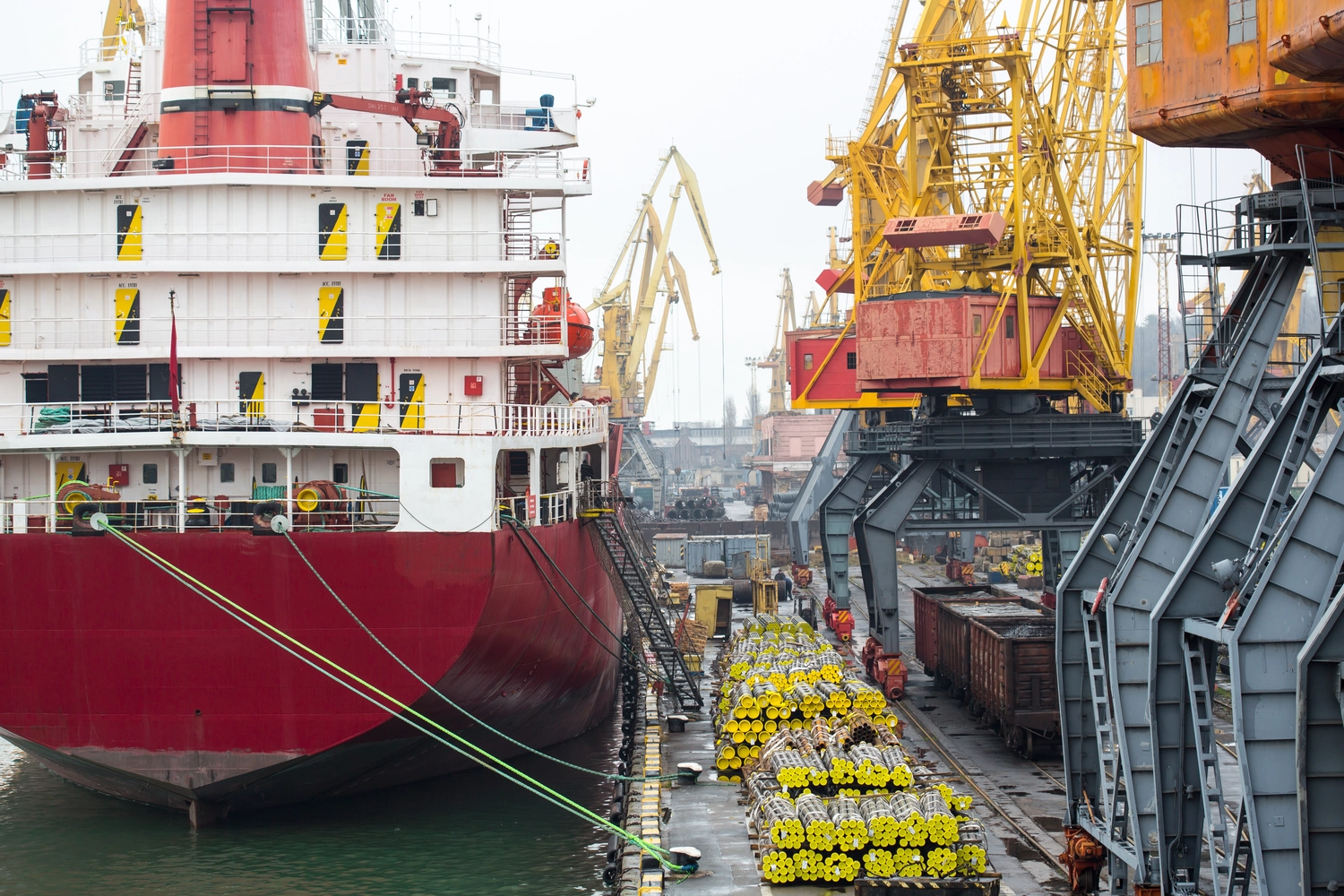 Flex Express Hamburg e.K. – Kurierdienste – Trockengutschiff beim Be- und Entladen im Hafen. Massengutfrachter im Hafen. Hafenterminal.